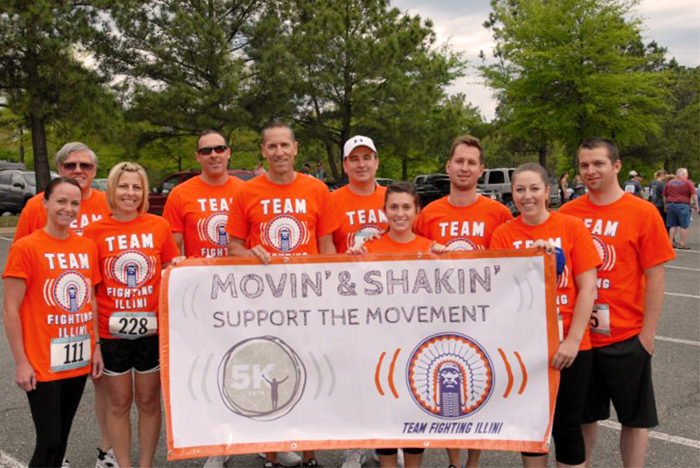 A team of 5K participants holds up a large 