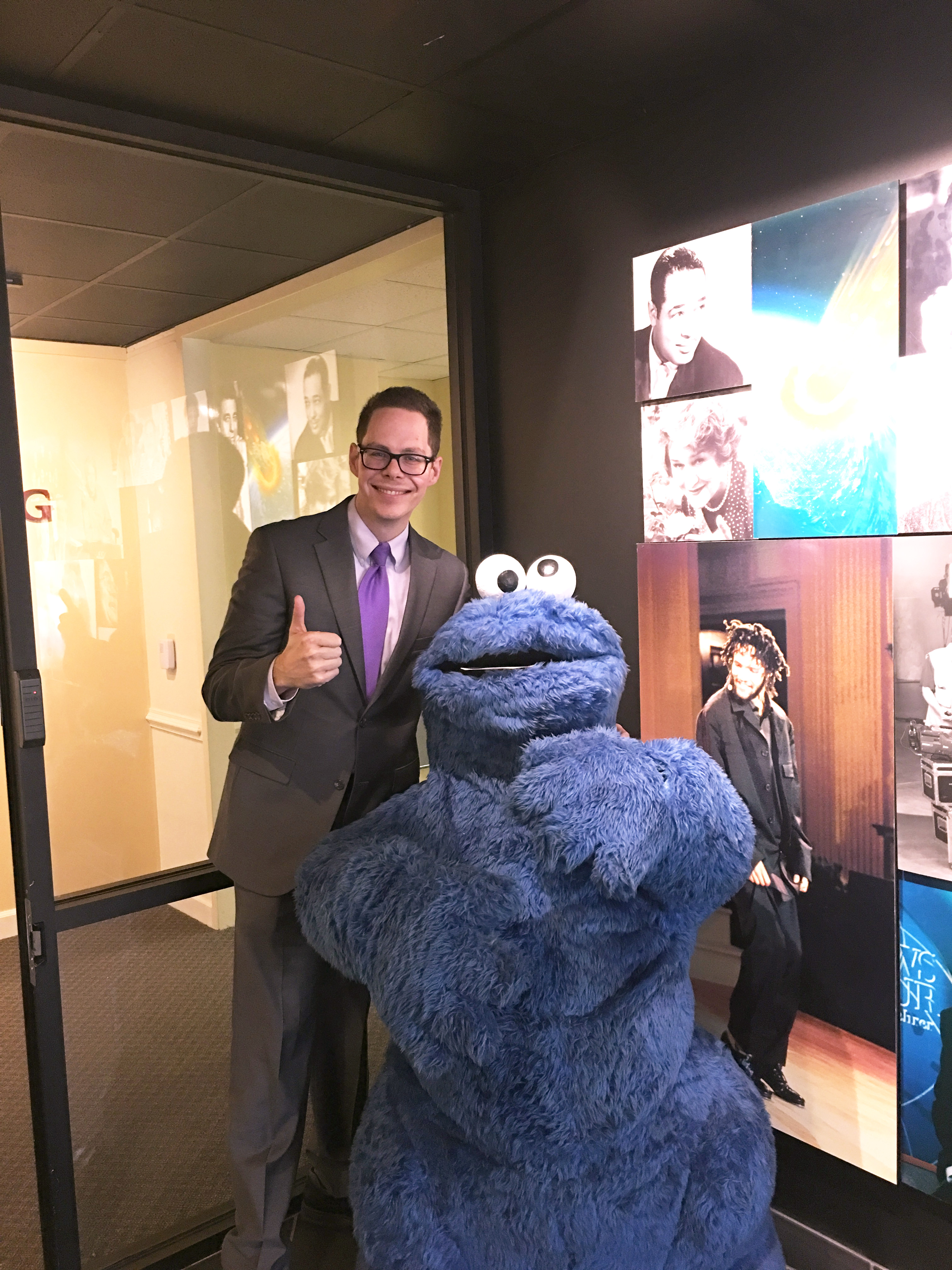 Dr. Jon Snider posing with a person dressed as Sesame Street's cookie monster at the PBS station in Richmond.
